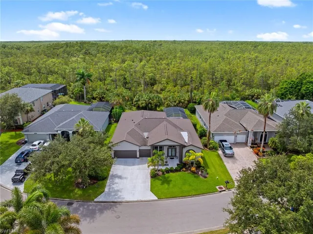 an aerial view of residential houses with outdoor space and trees