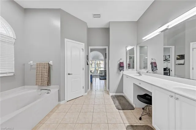 a bathroom with a tub sink and mirror
