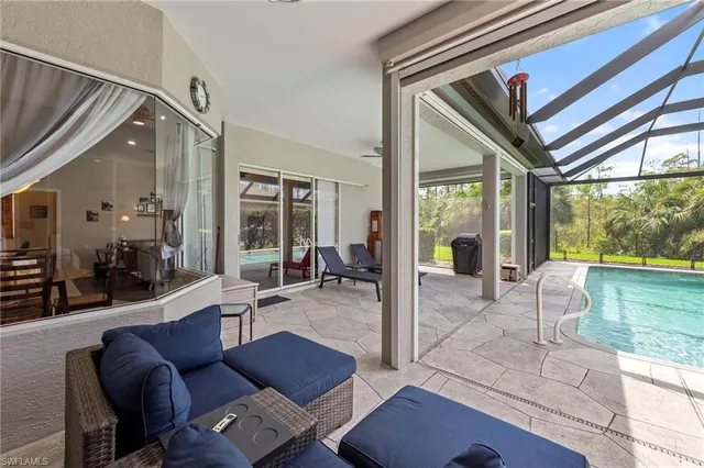 a living room with furniture and a floor to ceiling window