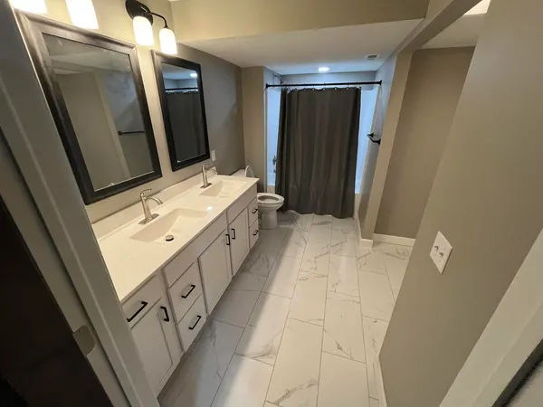 a bathroom with a double vanity sink and mirror