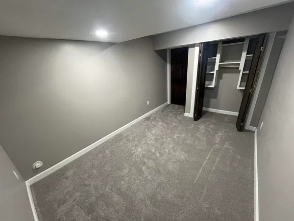 an empty room with closet and a window