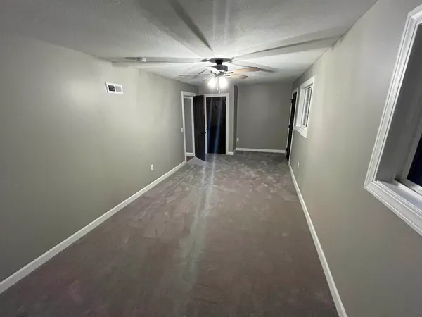 en empty room with windows and fan