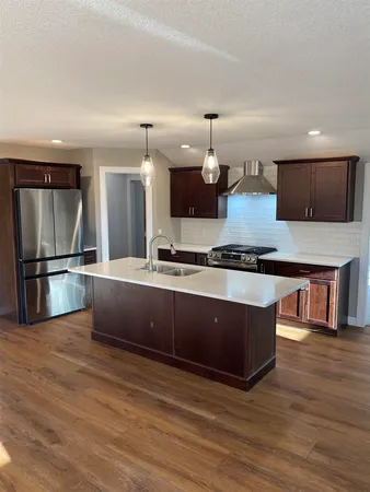 a kitchen with stainless steel appliances granite countertop a stove a sink and a refrigerator