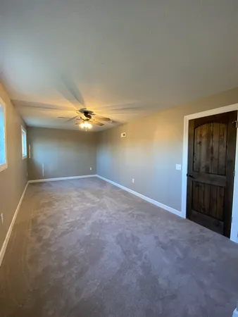 a view of an empty room with a ceiling fan