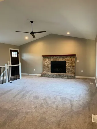 a view of empty room with wooden floor and fireplace