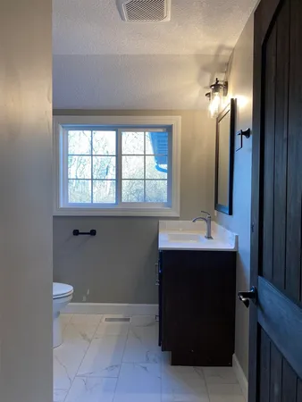 a bathroom with a sink and mirror with bathtub