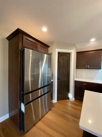 a kitchen with granite countertop a refrigerator and a sink