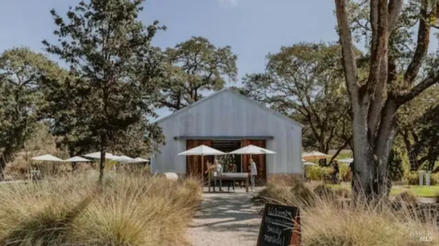 a backyard of a house with table and chairs under an umbrella