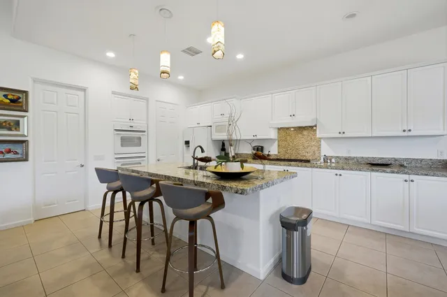 a kitchen with a sink white cabinets and appliances