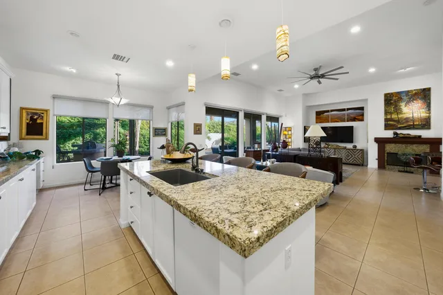 a kitchen with kitchen island granite countertop a large counter top couches and living room view