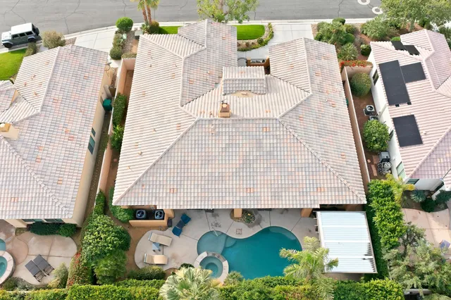 an aerial view of a house with pool and chairs