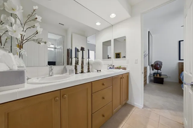 a spacious bathroom with a double vanity sink a mirror and a bathtub