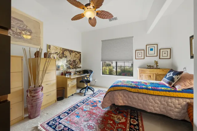 a bedroom with a bed dresser and window