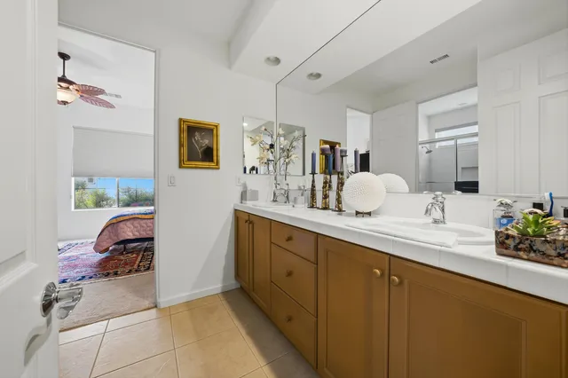 a en suite bathroom with a double vanity sink and a mirror
