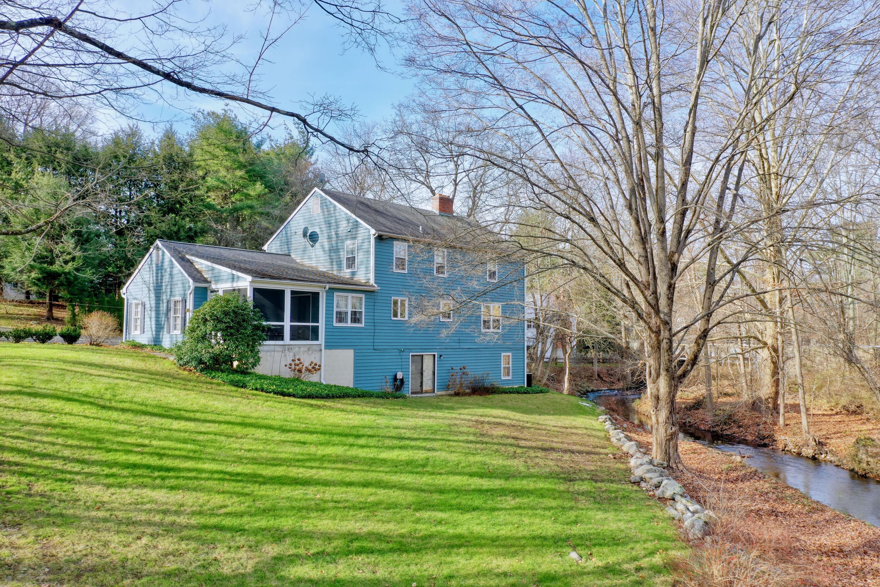 24 White Oak Shade Road New Canaan, CT 06840 - Photo 6 of 13 a front view of house with yard and green space