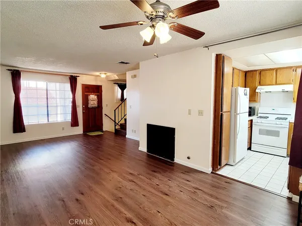 a view of a kitchen with a stove wooden floor a kitchen view and windows