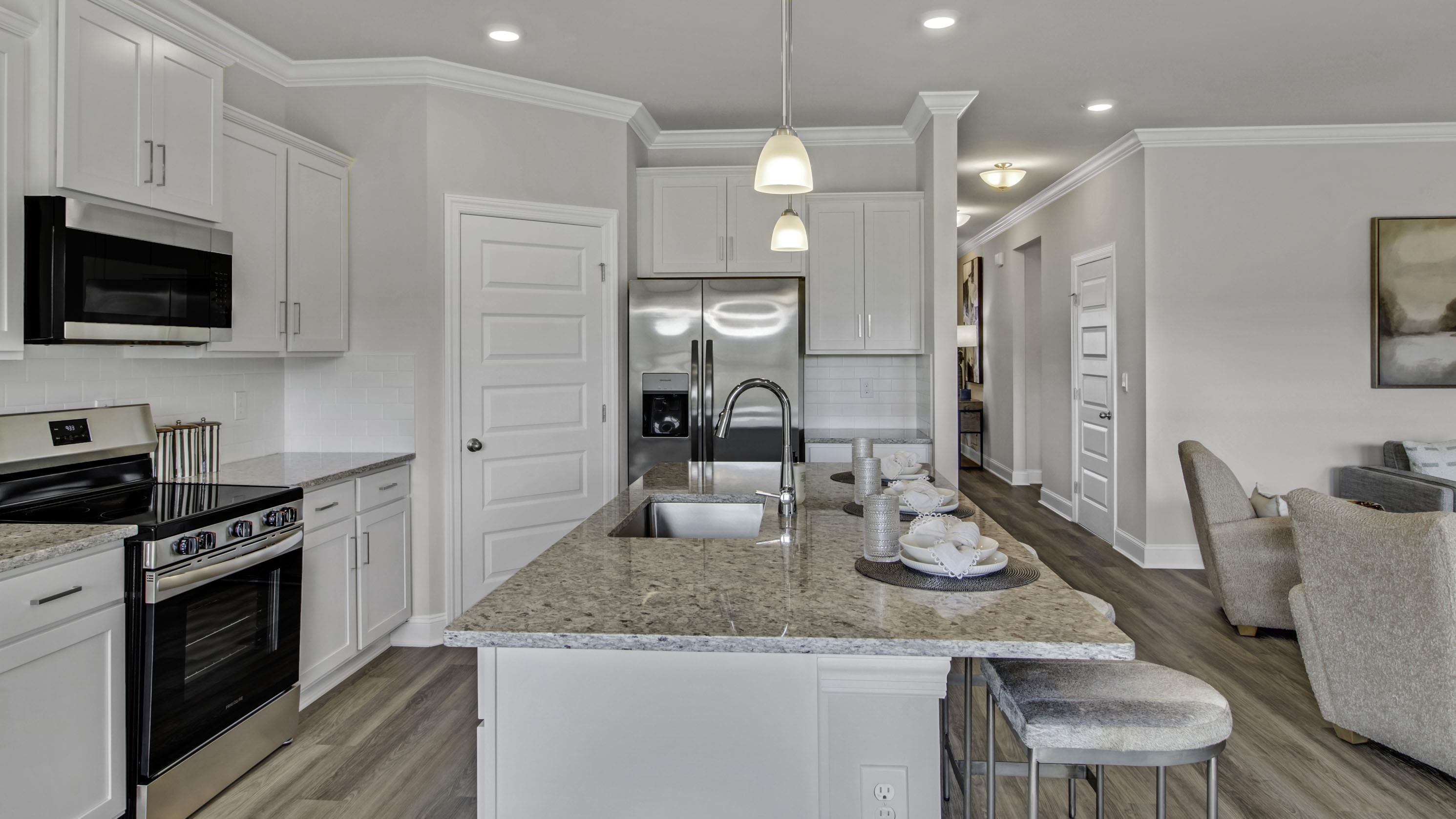 990 Mewborn Farm Road Oakland, TN 38060 - Photo 5 of 40 Kitchen with stainless steel appliances, white cabinets, light stone countertops, light wood-style floors, and ornamental molding