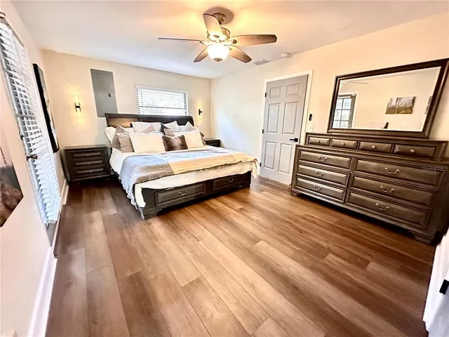 a bedroom with a bed and wooden floor