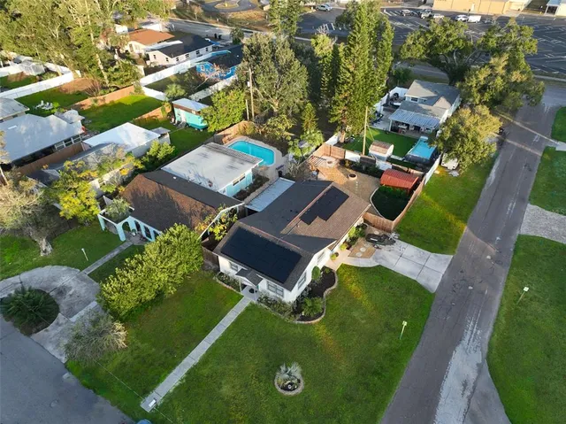 an aerial view of residential houses with outdoor space and trees