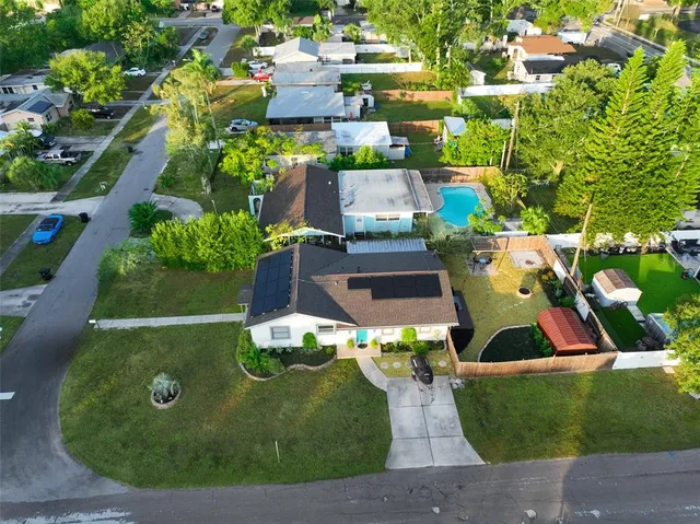 an aerial view of residential houses with outdoor space and trees