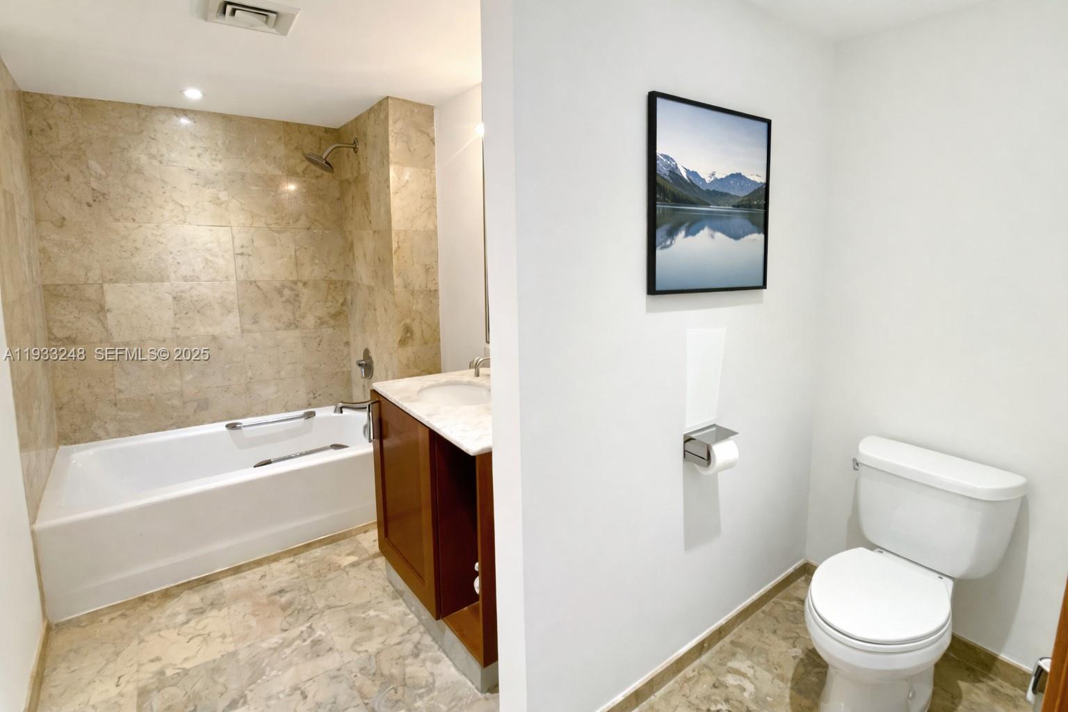9499 Collins Avenue, Unit 903 Surfside, FL 33154 - Photo 10 of 14 a bathroom with a toilet a sink and bathtub