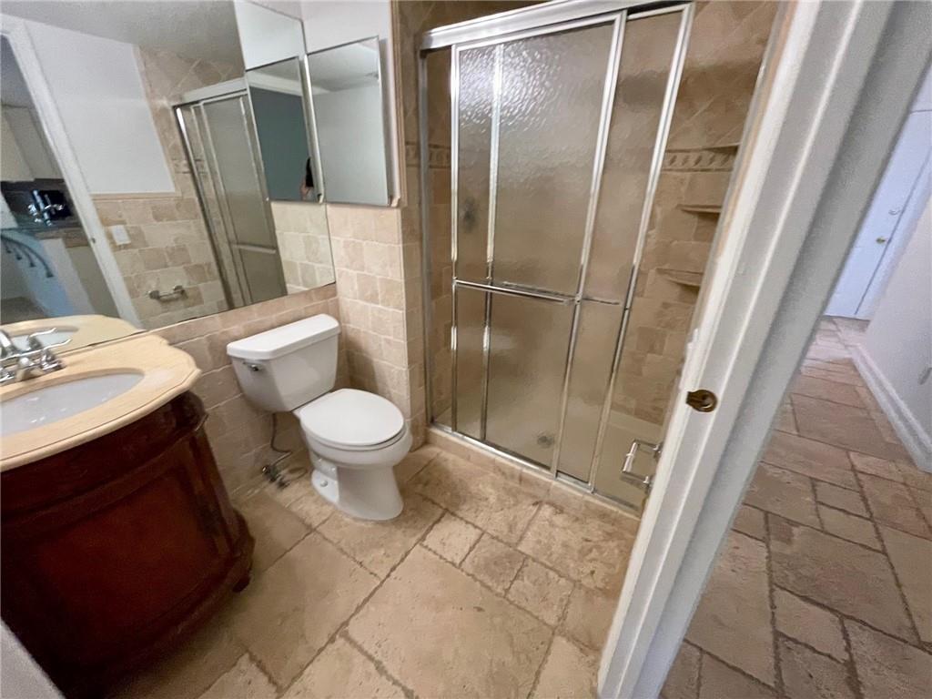10253 Riverbend Terrace Boca Raton, FL 33498 - Photo 14 of 33 a bathroom with a sink a toilet a mirror and shower