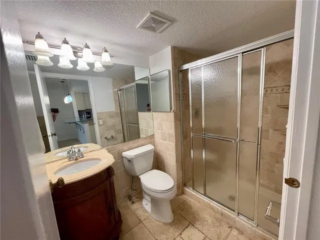 a bathroom with a double vanity sink toilet mirror and shower