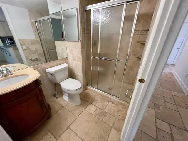 a bathroom with a sink a toilet a mirror and shower