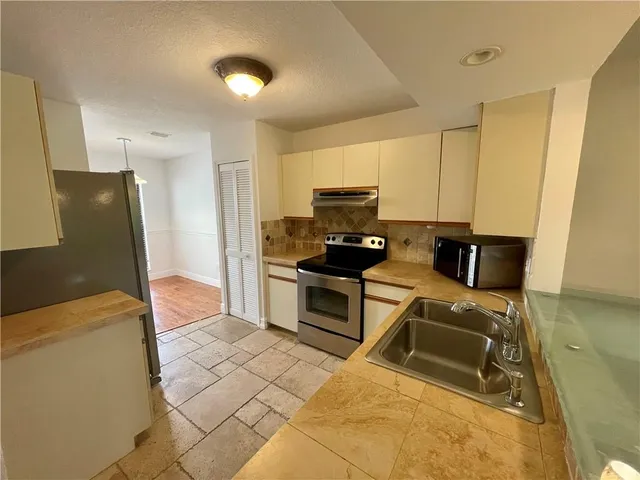 a kitchen with stainless steel appliances granite countertop a stove a sink and a refrigerator