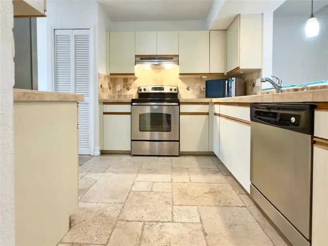 a kitchen with a stove top oven and cabinets