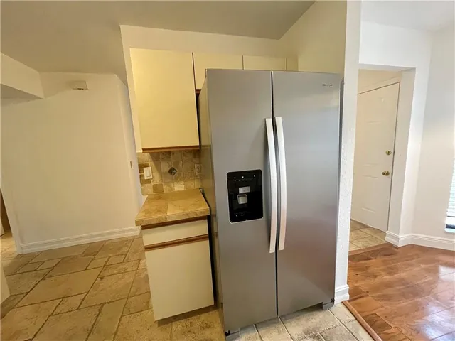 a metallic refrigerator freezer sitting in a kitchen