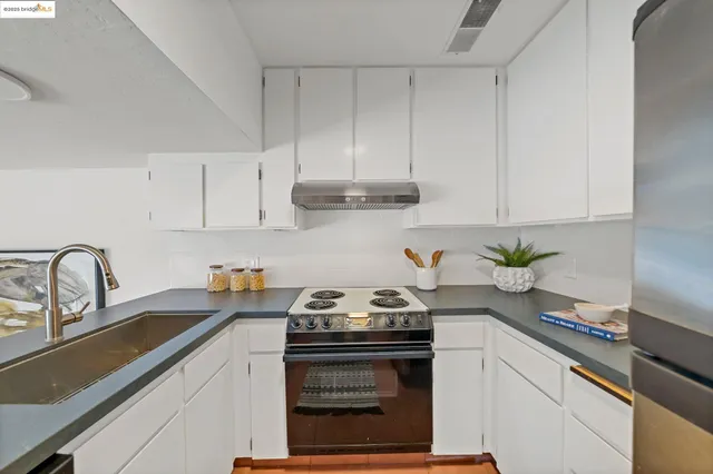 a kitchen with granite countertop a sink stainless steel appliances and cabinets