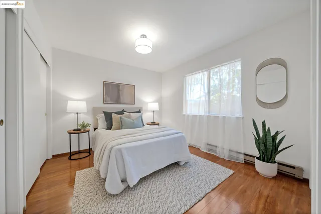a spacious bedroom with a bed and a potted plant