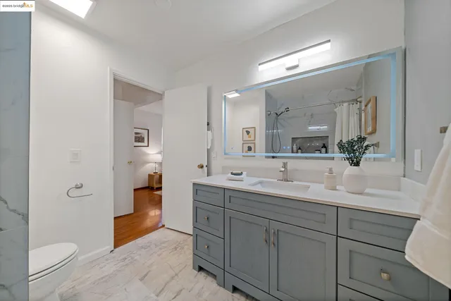 a bathroom with a double vanity sink toilet mirror and bathtub
