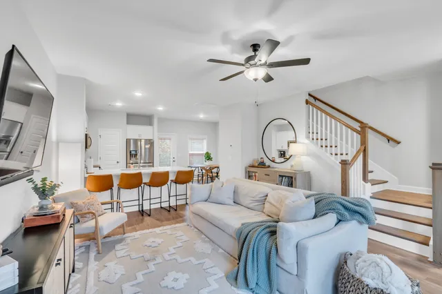 a living room with furniture kitchen view and a chandelier