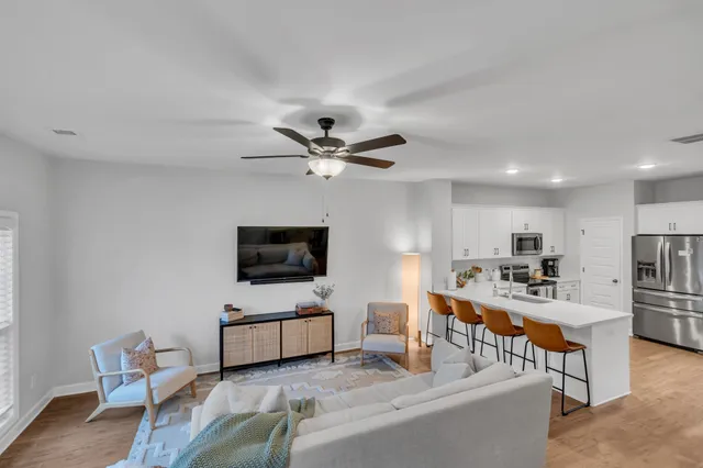 a kitchen with stainless steel appliances a refrigerator a stove a sink dishwasher and a refrigerator with wooden floor