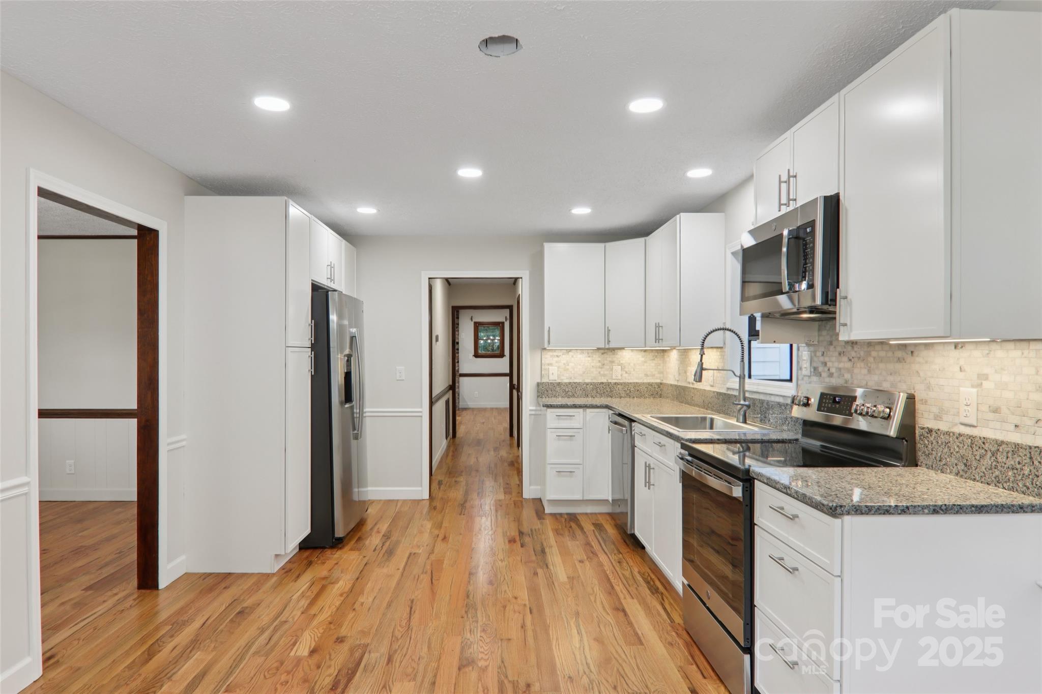 5 Timothy Lane Candler, NC 28715 - Photo 14 of 48 a kitchen with stainless steel appliances granite countertop a refrigerator a sink dishwasher a stove and white countertops with wooden floor