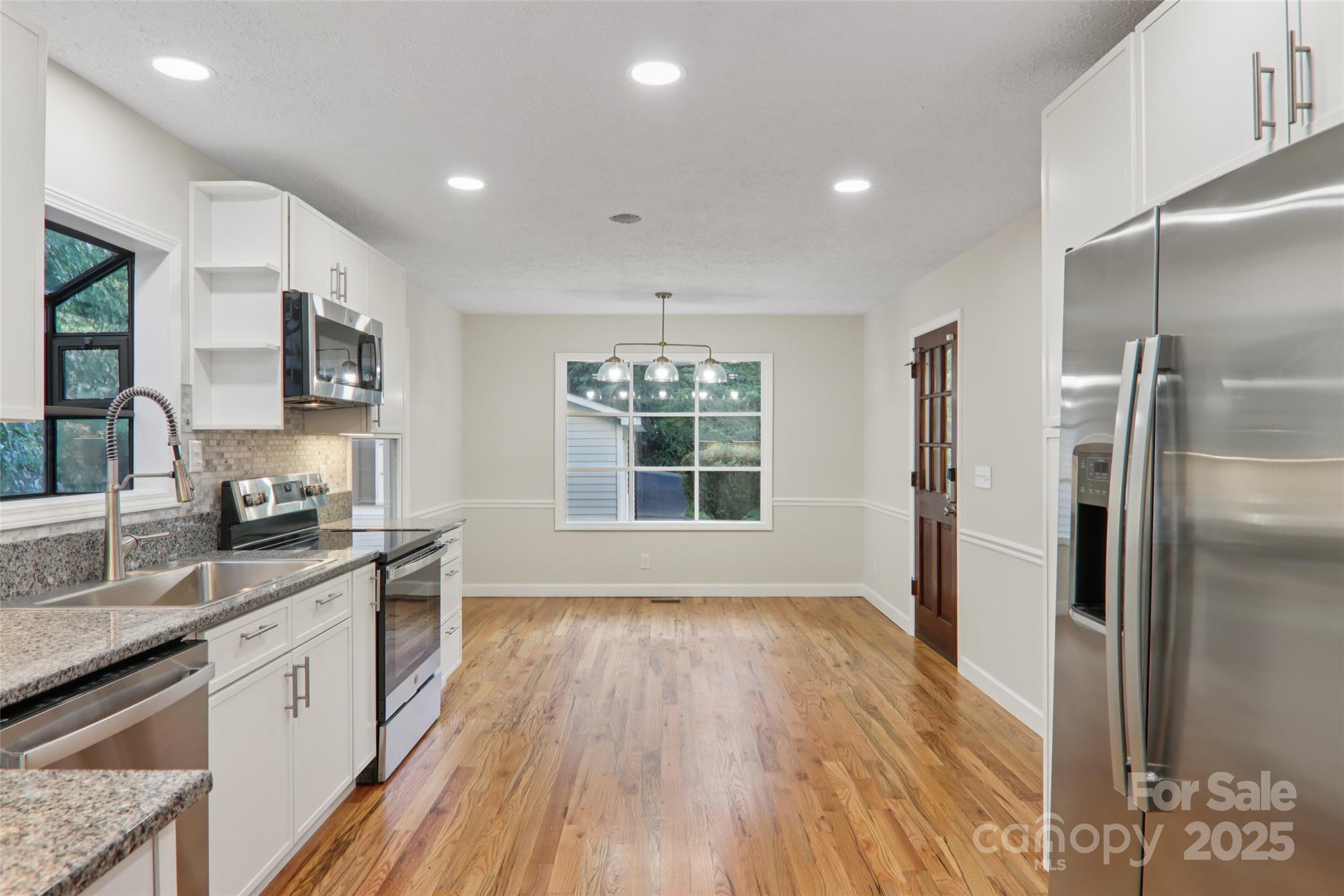 5 Timothy Lane Candler, NC 28715 - Photo 15 of 48 a kitchen with stainless steel appliances granite countertop a refrigerator a sink dishwasher a kitchen island with wooden floor and cabinets