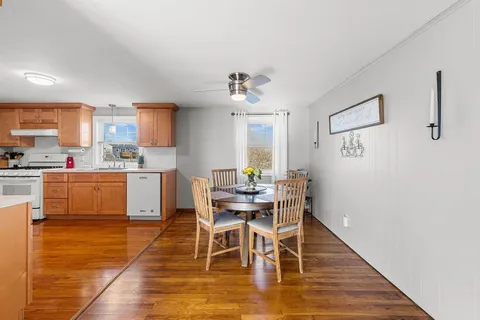 a dining room with kitchen island stainless steel appliances a table and chairs