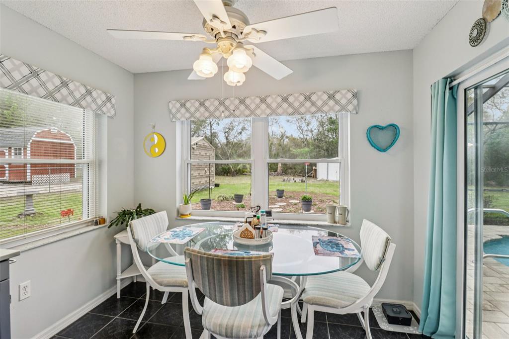 2963 Southwest 137th Place Ocala, FL 34473 - Photo 12 of 51 a view of a dining room with furniture a chandelier and large windows