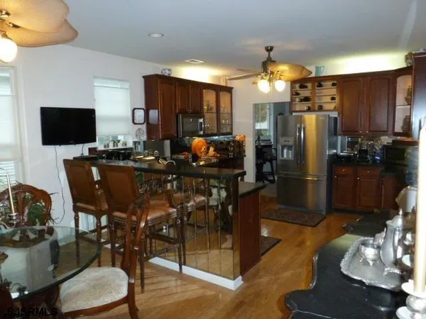 a view of a dining room with furniture a kitchen and chandelier