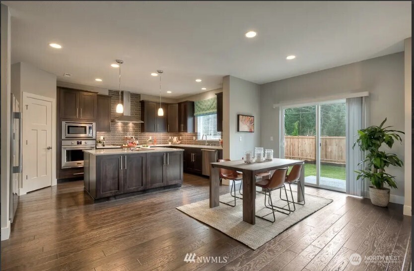 3606 200th Place Southeast Bothell, WA 98012 - Photo 7 of 28 a living room with stainless steel appliances kitchen island granite countertop furniture wooden floor and a kitchen view