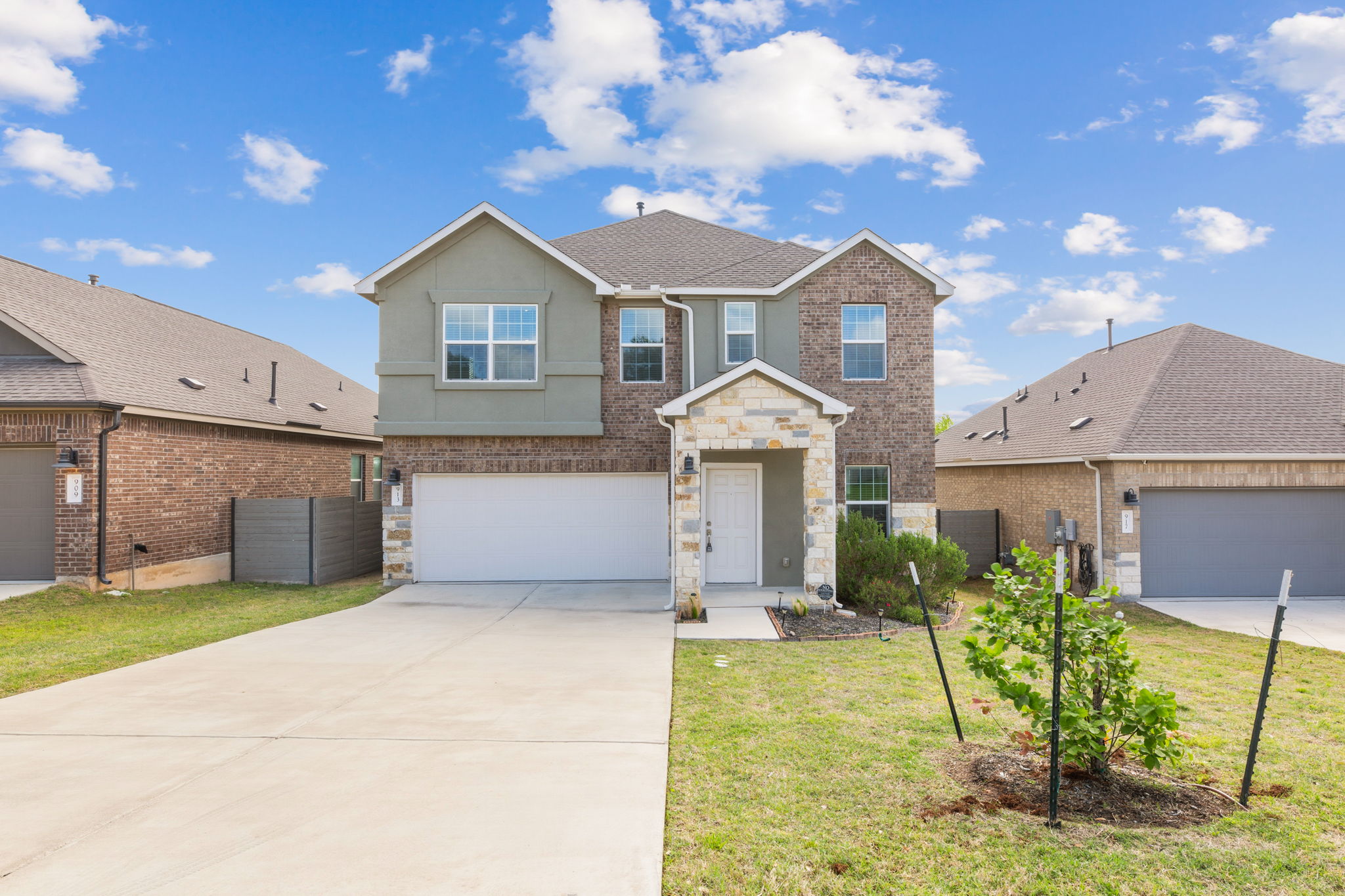 Traditional home featuring concrete driveway, stone siding, and a garage