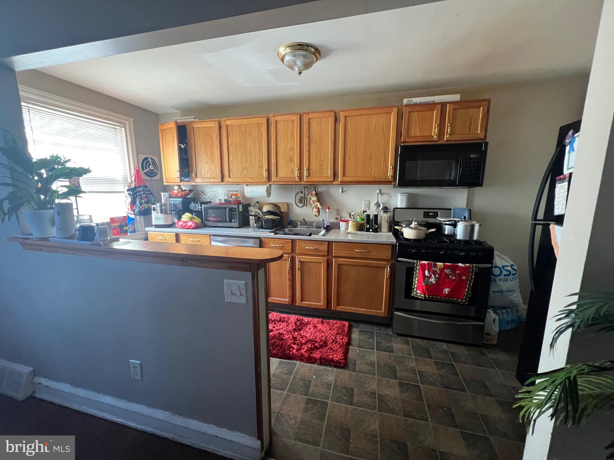 2818 Hellerman Street Philadelphia, PA 19149 - Photo 6 of 15 a kitchen with kitchen island granite countertop a sink stove and cabinets