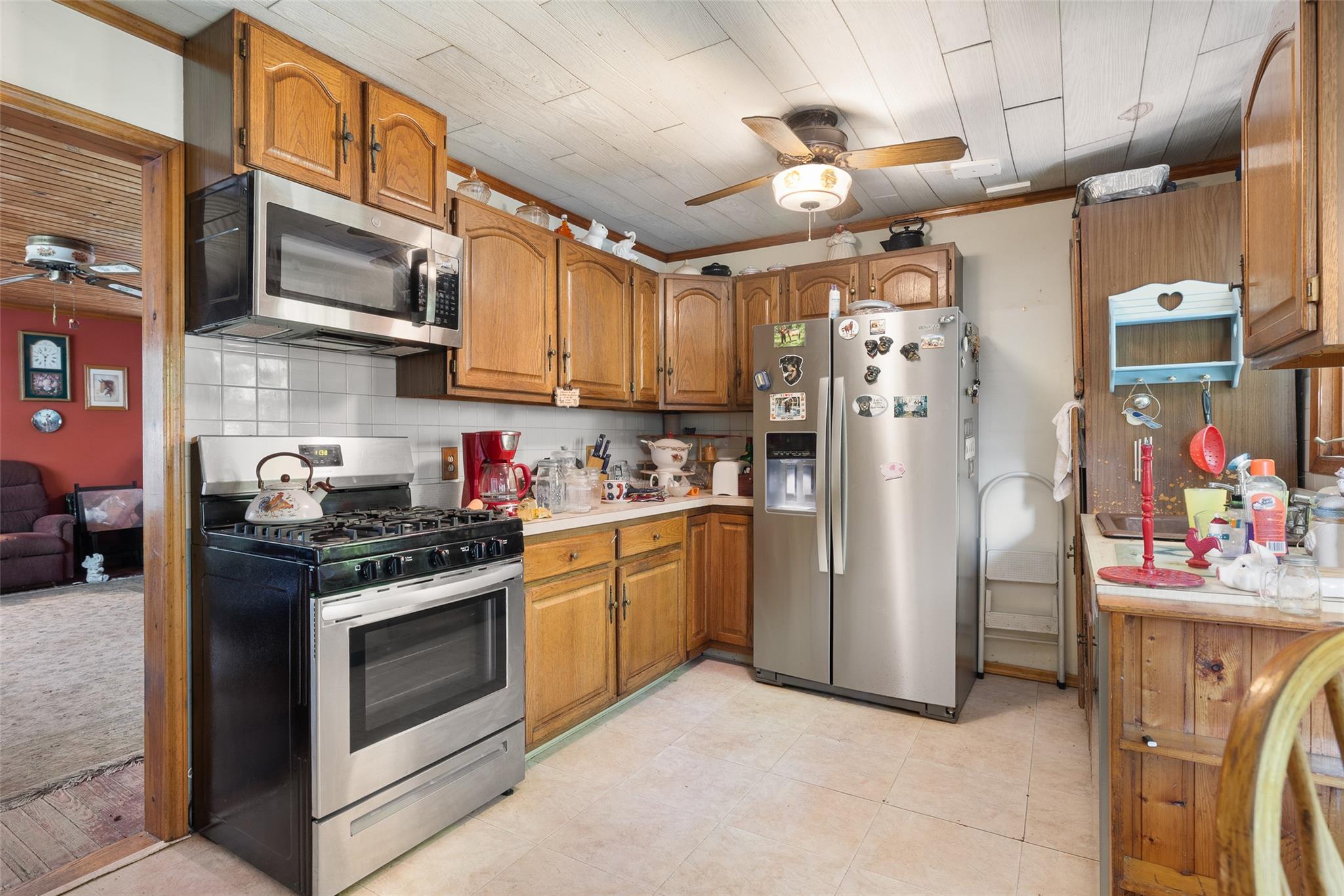 33 North Coleman Road Centereach, NY 11720 - Photo 15 of 40 Kitchen with stainless steel appliances, ceiling fan, brown cabinets, and light countertops