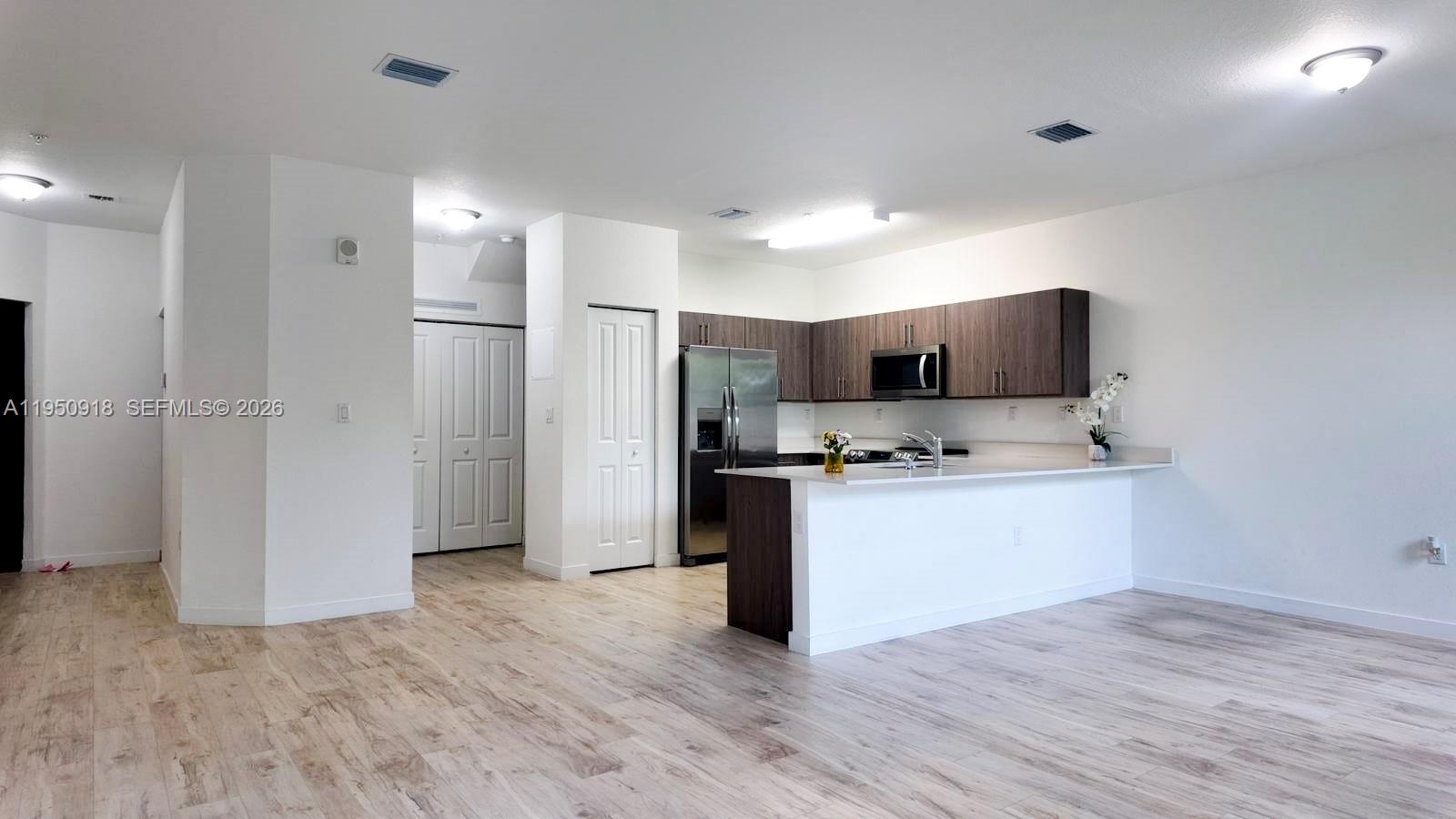 15540 Southwest 136th Street, Unit 204 Miami, FL 33196 - Photo 4 of 21 a kitchen with a refrigerator and a stove top oven