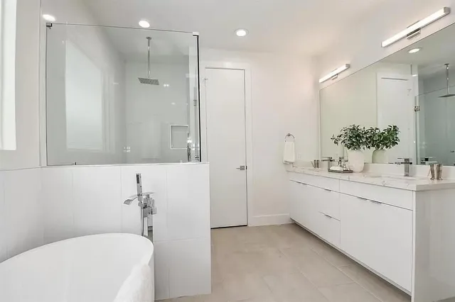 a bathroom with a granite countertop sink mirror and a bathtub