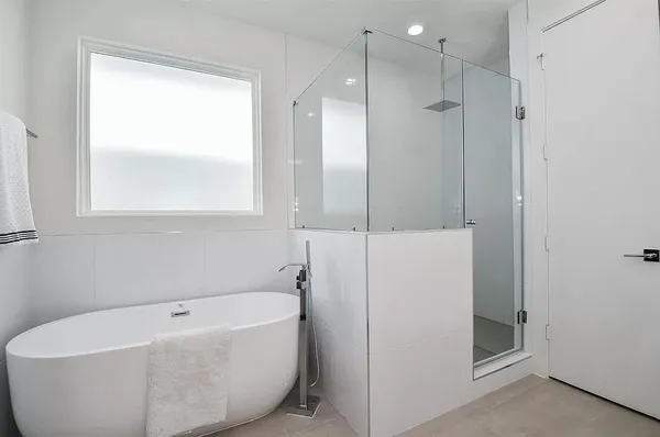 a white bath tub sitting next to a shower