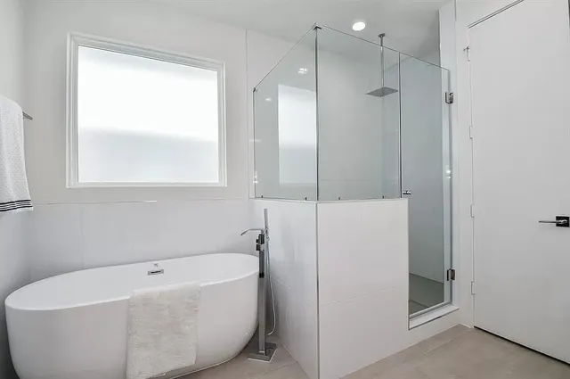 a white bath tub sitting next to a shower