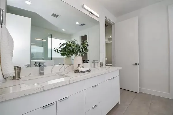 a bathroom with double sink and a mirror